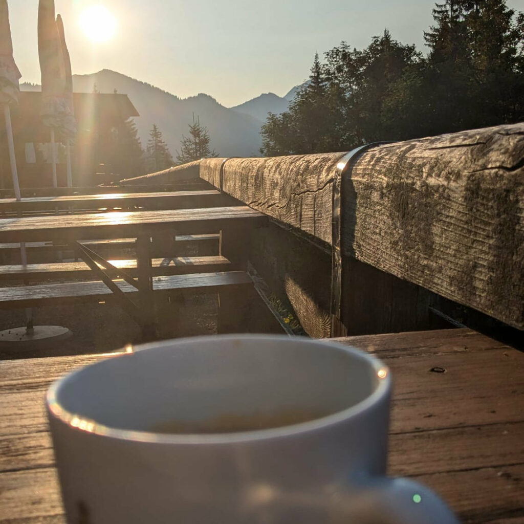Kaffeetasse im Sonnenaufgang auf der Firstalm-Terrasse
